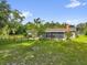 Picturesque backyard featuring a fenced yard, screened porch, and cozy fire pit area at 1008 Bay Ave, Lake Wales, FL 33859