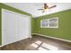 Bedroom featuring green walls, wood-look flooring, window, and closet with sliding door at 1008 Bay Ave, Lake Wales, FL 33859