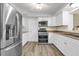 Bright kitchen features stainless steel appliances, white cabinetry, and wood-look flooring at 1008 Bay Ave, Lake Wales, FL 33859