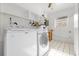 Clean laundry room with white tile floors, washer, dryer, and built-in shelving at 1008 Bay Ave, Lake Wales, FL 33859