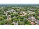 An aerial view shows a home with solar panels surrounded by mature trees in a residential neighborhood at 1039 Eagles Forrest Dr, Apopka, FL 32712