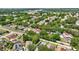 An aerial view shows a home with solar panels surrounded by mature trees in a residential neighborhood at 1039 Eagles Forrest Dr, Apopka, FL 32712