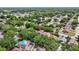 An aerial view shows a home with solar panels surrounded by mature trees in a residential neighborhood at 1039 Eagles Forrest Dr, Apopka, FL 32712