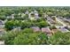 An aerial view shows a home with solar panels surrounded by mature trees in a residential neighborhood at 1039 Eagles Forrest Dr, Apopka, FL 32712