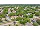 An aerial view shows a home with solar panels surrounded by mature trees in a residential neighborhood at 1039 Eagles Forrest Dr, Apopka, FL 32712