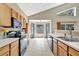 Bright kitchen featuring light wood cabinets, white tile floors, black appliances and a window looking out onto a yard at 1039 Eagles Forrest Dr, Apopka, FL 32712