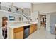 Open-concept kitchen featuring white countertops, light wood cabinets, a breakfast bar, and views of the staircase and dining area at 1039 Eagles Forrest Dr, Apopka, FL 32712