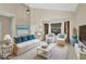 Bright living room featuring wicker furniture with blue accents, neutral walls, and tile flooring at 1039 Eagles Forrest Dr, Apopka, FL 32712