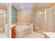Bathroom featuring a tiled bathtub and a glass-enclosed shower providing luxurious bathing at 1128 Travertine Ter, Sanford, FL 32771