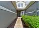 Pathway leads to front door, lined with mulched beds and lush green hedges at 1128 Travertine Ter, Sanford, FL 32771