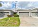 Townhouse exterior features a multi-car garage, neutral paint, manicured shrubs and green grass at 1128 Travertine Ter, Sanford, FL 32771