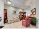 A traditional living room with tile floors, a floral sofa, and light-green colored walls at 1128 Travertine Ter, Sanford, FL 32771