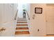 Carpeted stairs with wood railing lead to upper level, next to two closets at 1128 Travertine Ter, Sanford, FL 32771