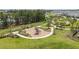 Aerial view of community playground surrounded by lush greenery, a walking trail and a pond at 12821 Harvest Rain Ave, Winter Garden, FL 34787