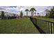 Fenced community dog park with lush green grass, palm trees and a fire hydrant at 12821 Harvest Rain Ave, Winter Garden, FL 34787