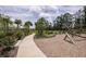 Path leads to a community playground with climbing ropes and swings on a manicured lot at 12821 Harvest Rain Ave, Winter Garden, FL 34787