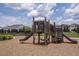 Community playground with slides, climbing nets and wooden features with homes in the background at 12821 Harvest Rain Ave, Winter Garden, FL 34787