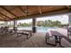 Community pool with picnic tables under a covered patio and many lounge chairs at 12821 Harvest Rain Ave, Winter Garden, FL 34787