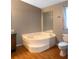 Corner bathtub in the bathroom with a mirror on the wall and hardwood floors at 13010 Plum Lake Cir, Minneola, FL 34715
