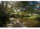 Inviting single-story home with a driveway, mature trees, and a basketball hoop at 13010 Plum Lake Cir, Minneola, FL 34715