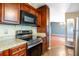 Kitchen featuring stainless steel appliances, wood cabinets, and a view into the living space at 13010 Plum Lake Cir, Minneola, FL 34715