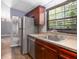 Functional kitchen with stainless steel appliances, wood cabinets, and a window over the sink at 13010 Plum Lake Cir, Minneola, FL 34715