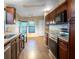 Spacious kitchen with stainless steel appliances, wood cabinets, and a pass-through window to the dining area at 13010 Plum Lake Cir, Minneola, FL 34715