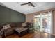 Inviting living room with wood flooring, a comfortable couch, and a sliding glass door to the outside at 13010 Plum Lake Cir, Minneola, FL 34715