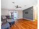 Open living room with hardwood floors, a ceiling fan, and sliding glass doors to an outdoor area at 13010 Plum Lake Cir, Minneola, FL 34715