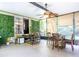 Bright sunroom with decorative wall greenery, ceiling fan, and dining table with chairs near the screen windows at 13010 Plum Lake Cir, Minneola, FL 34715