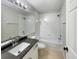 Clean bathroom featuring a vanity with a granite countertop and a shower-tub combo at 13108 Long Pine Trl, Clermont, FL 34711