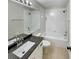 Well-lit bathroom with a granite vanity, a toilet, and a shower-tub combination at 13108 Long Pine Trl, Clermont, FL 34711