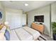 Bright bedroom features a comfortable bed, large closet, and modern dresser with wall-mounted TV at 13108 Long Pine Trl, Clermont, FL 34711