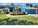 Charming blue home with a lush landscaped front yard and a red front door at 13108 Long Pine Trl, Clermont, FL 34711