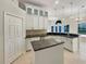 Stylish kitchen featuring white cabinetry, granite countertops, island and stainless steel appliances at 13108 Long Pine Trl, Clermont, FL 34711