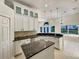 Stylish kitchen featuring white cabinetry, granite countertops, island and stainless steel appliances at 13108 Long Pine Trl, Clermont, FL 34711