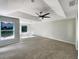 Spacious living room with tray ceiling, ceiling fan, plush carpeting, and backyard views at 13108 Long Pine Trl, Clermont, FL 34711