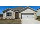Charming single-story home with neutral siding, white trim, and a two-car garage in a well-manicured lawn at 1311 Lawndale Ct, Ormond Beach, FL 32174