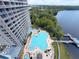 Aerial view showcasing a sparkling pool, lush greenery, and the building's modern architecture at 13427 Blue Heron Dr # 2-1401, Orlando, FL 32821
