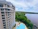 Stunning aerial view of condo building, blue pool, and beautiful lake at 13427 Blue Heron Dr # 2-1401, Orlando, FL 32821