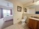 Well-lit bathroom featuring granite countertop, and toilet near bedroom at 13427 Blue Heron Dr # 2-1401, Orlando, FL 32821