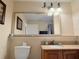 Well-lit bathroom featuring granite countertop, wood cabinets, and framed mirror at 13427 Blue Heron Dr # 2-1401, Orlando, FL 32821