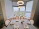 Bright dining area with chandelier lighting and bay window showcasing beautiful treetop views at 13427 Blue Heron Dr # 2-1401, Orlando, FL 32821