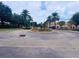 Circular driveway featuring a well-maintained fountain, lush landscaping, and mature palm trees at 13427 Blue Heron Dr # 2-1401, Orlando, FL 32821