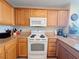 This kitchen has wooden cabinets, stone countertops and white oven/range at 13427 Blue Heron Dr # 2-1401, Orlando, FL 32821