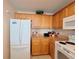 Bright kitchen features wooden cabinetry, granite countertops, and modern white appliances at 13427 Blue Heron Dr # 2-1401, Orlando, FL 32821