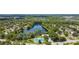 A captivating aerial view of the community, showcasing the serene lake and inviting tennis courts amid lush greenery at 145 Lakeside Cir, Sanford, FL 32773