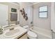 Bright bathroom featuring a tub with shower, white tile surround, and decorative accents at 145 Lakeside Cir, Sanford, FL 32773