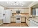 Bright kitchen featuring white appliances, ample cabinet space, and tile floors at 145 Lakeside Cir, Sanford, FL 32773