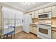 Kitchen with white appliances, tiled floor and eat in breakfast table at 145 Lakeside Cir, Sanford, FL 32773